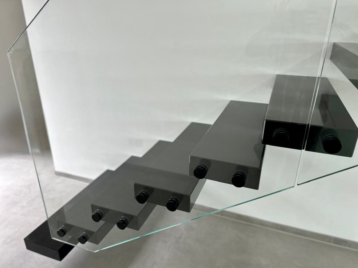 Kragarmtreppe mit Granitstufen in Köln, schwebende Bauweise an Stahlbetonwand