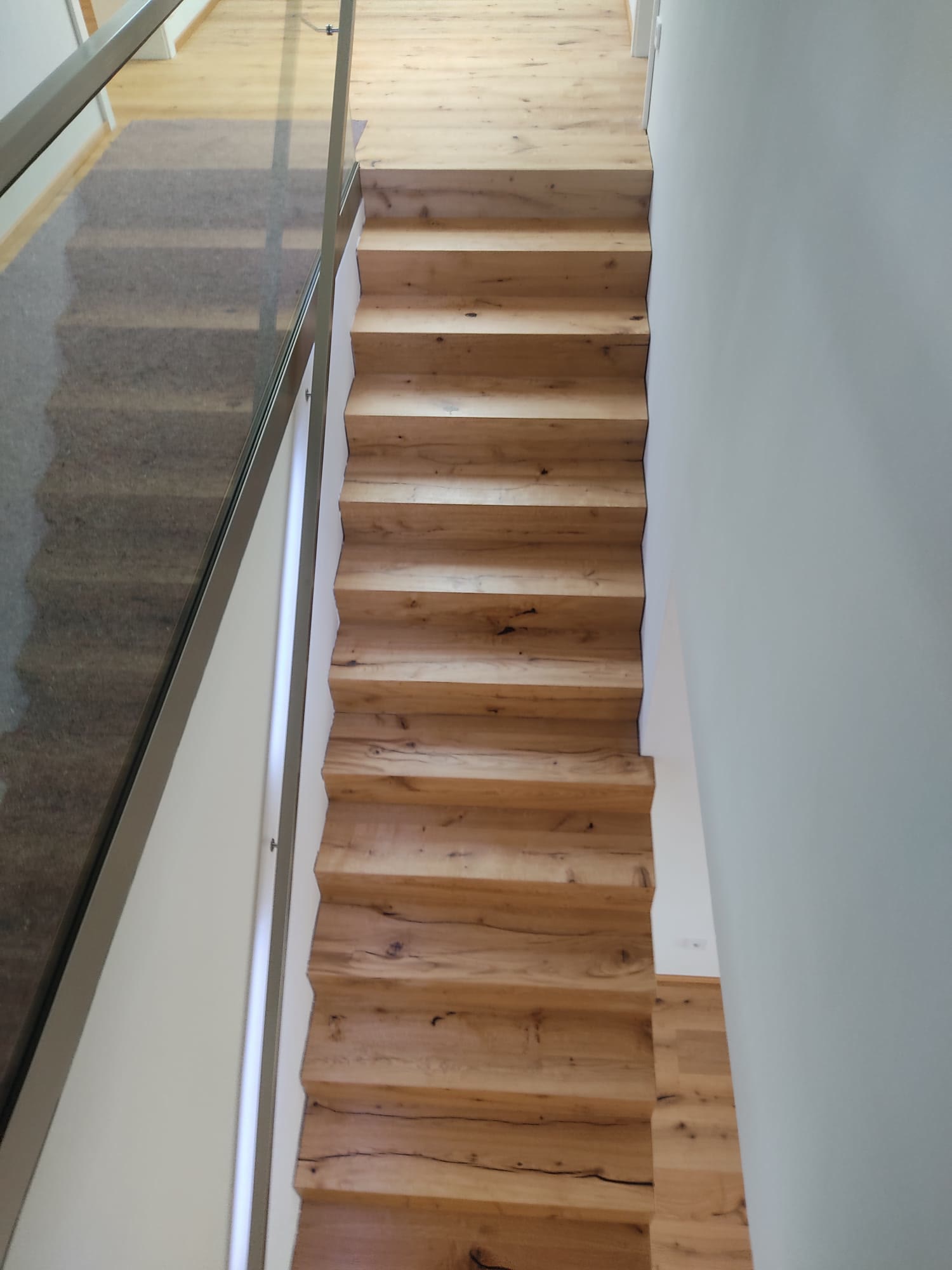 Umbau im Bild: links die noch rohe Betontreppe, rechts derselbe Lauf bereits mit Massivholz belegt