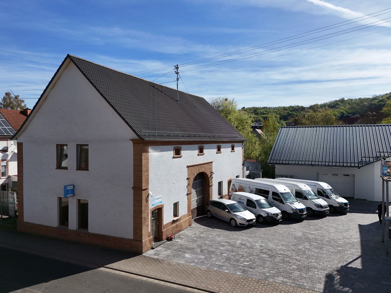 Firmensitz der AN Treppenbau GmbH in Herschweiler-Pettersheim, davor die Fahrzeuge des Montageteams
