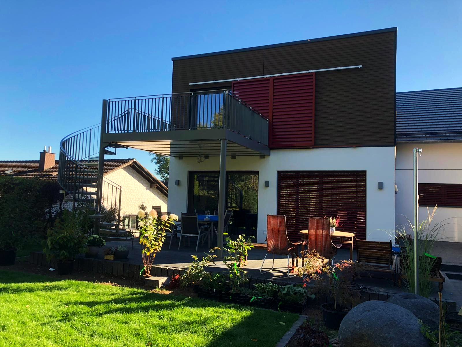 Stahlbalkon mit Stabgeländer und Außenwendeltreppe an einem Einfamilienhaus, gebaut von AN Metallbau